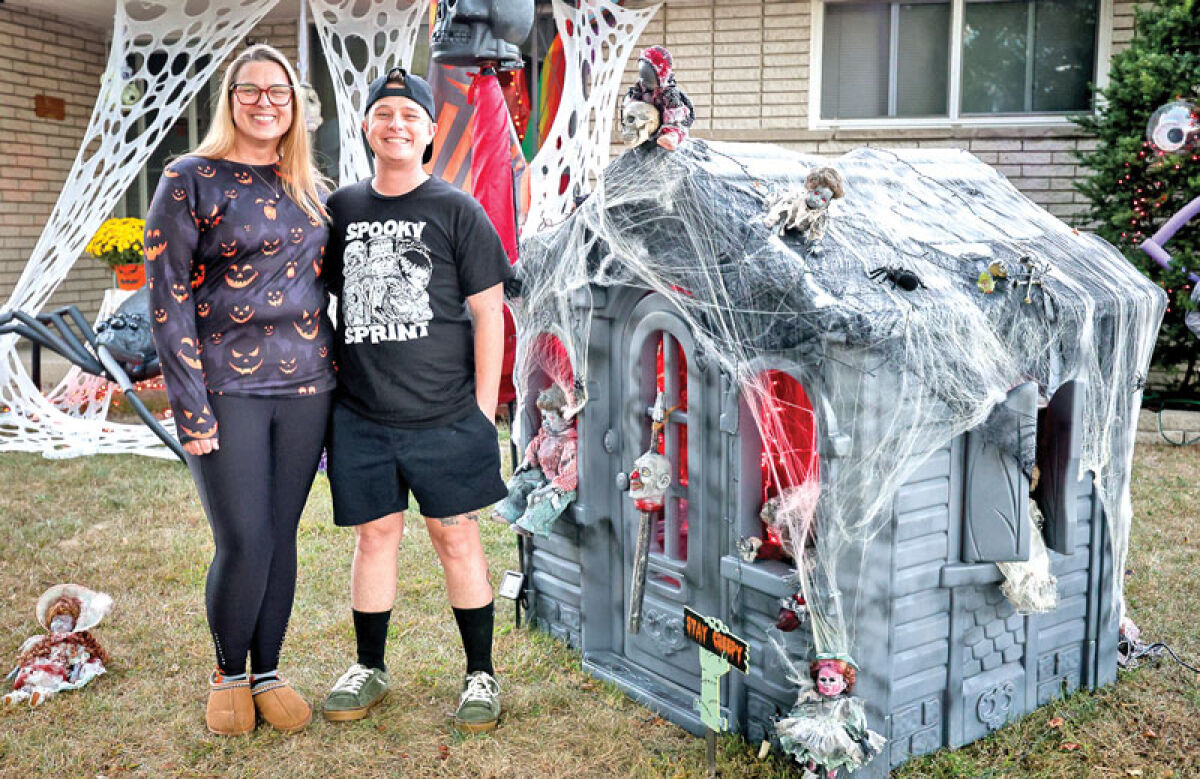  Warren residents Braxton Young and Kat Young stand near one of their homemade Halloween displays. 