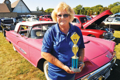  Janet Bartello, at the Holy Cross Classic Cruisers show, holds the seventh first-place award she has won this year. Her 1959 hot pink Ford Thunderbird is always a car show favorite. 