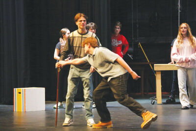  Confronted by the Man in the Yellow Suit (played by junior Zachary Tomlinson, left), Jesse Tuck (played by sophomore Carson Colby) creates a distraction in order to let him and Winnie Foster escape a carnival before the villain can reveal Tuck’s true age. 