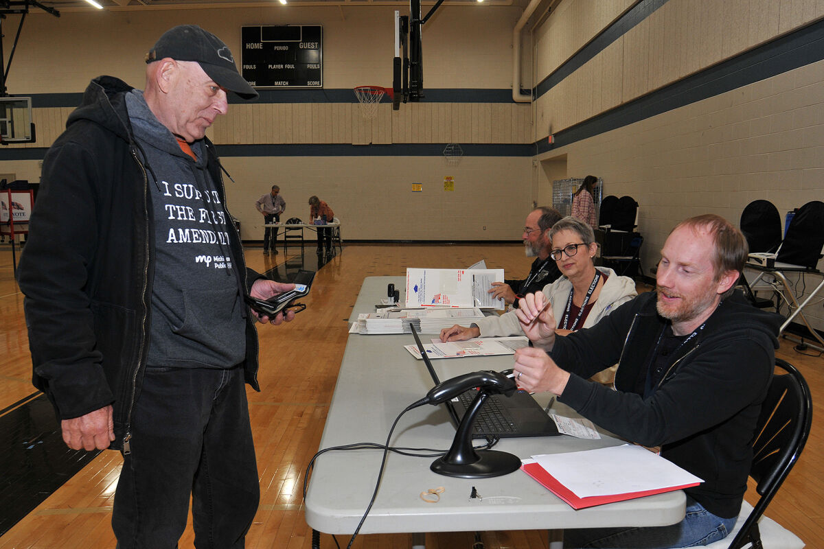  Royal Oak poll workers assist a voter at Royal Oak High School during the Nov. 4 general election.  