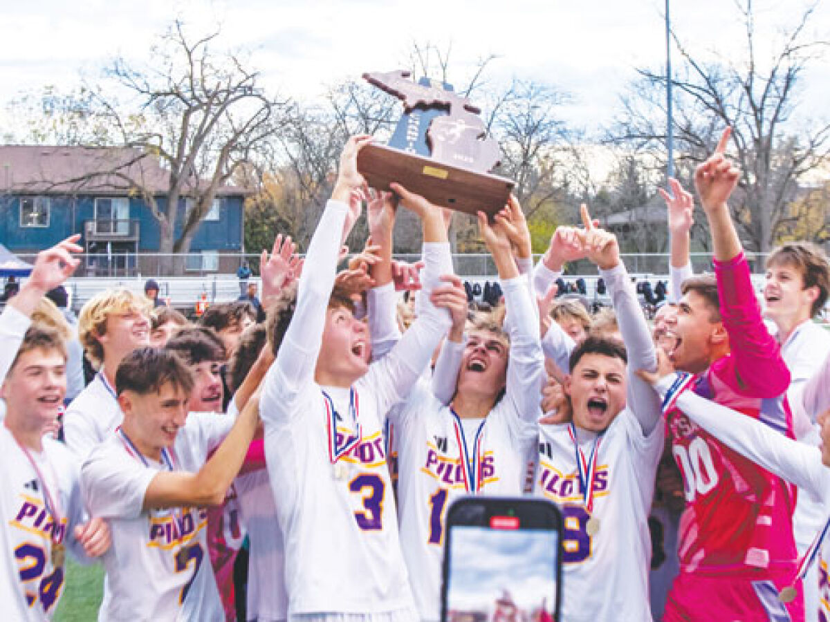  The 2025 De La Salle Pilots celebrate with the Michigan High School Sports Association Division 2 state championship trophy on Nov. 1 at Grand Ledge high school.  