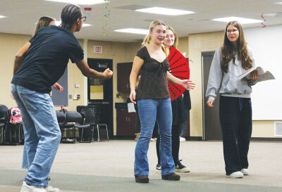  The Baker (junior Rylie Ellis, left) compares an ear of corn to the hair of Cinderella’s stepsisters and stepmother to see if their hair is as yellow as corn. 