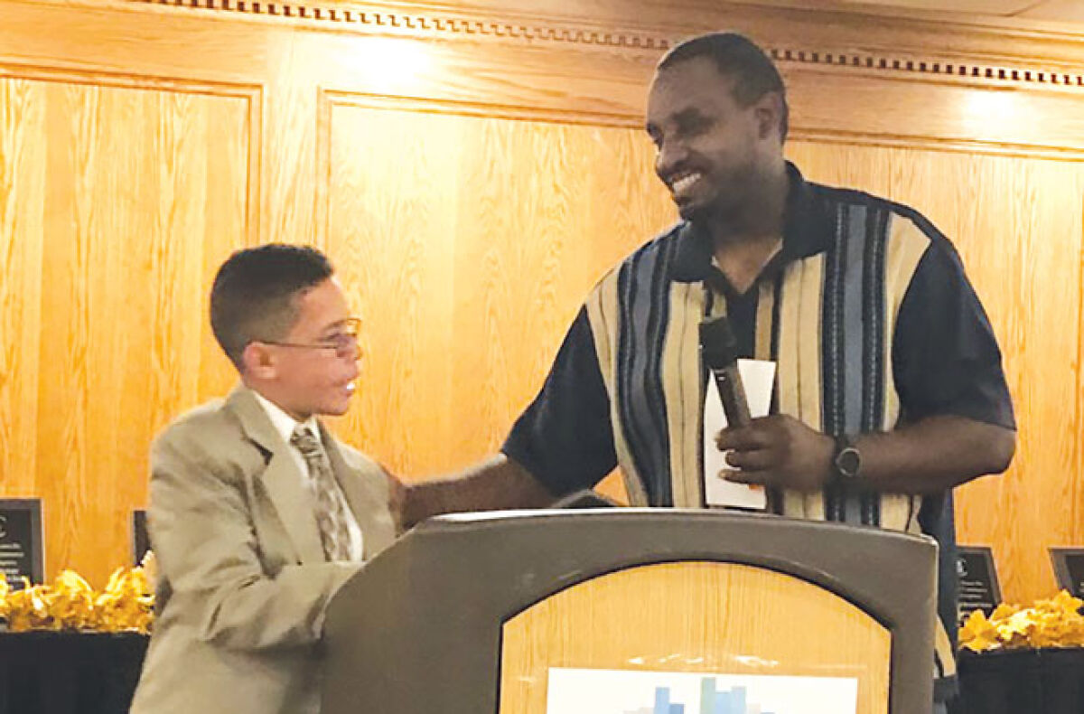  Dominic Miller, 13, left, receives his award from Eastpointe City Council member Rob Baker. 