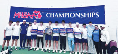 Liggett players and staff stand under the Michigan High School Athletic Association Championships banner after winning states. 