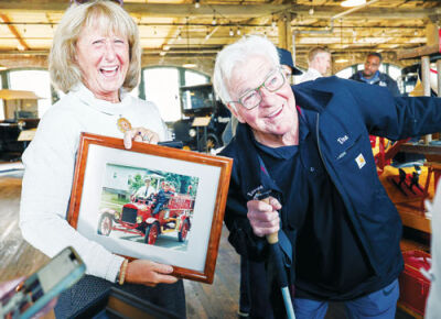  Kim Schmidt, left, holds a photo of her husband, Donald Schmidt, a retired Eastpointe Fire Department captain, as he drives the fire truck in a Memorial Day parade.  