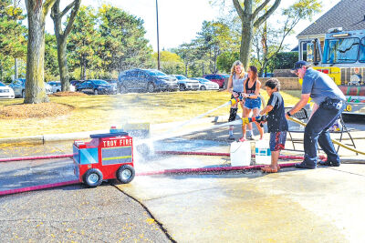  Community residents enjoy spraying water with the miniature trucks during the Troy Fire Department’s Open House in October. 