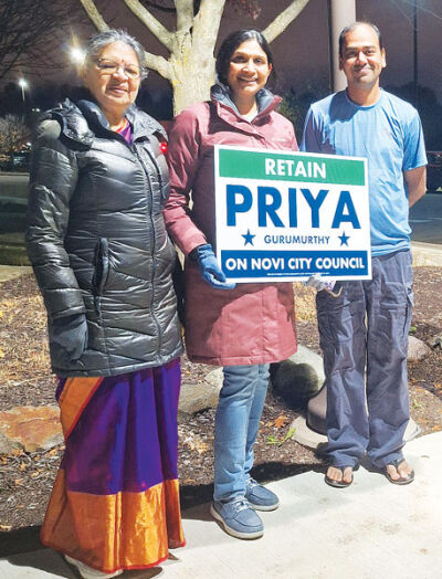  Priya Gurumurthy campaigns outside the Novi Civic Center on Nov. 4 with her friend Jaya Natrajan, left, and a supporter. 