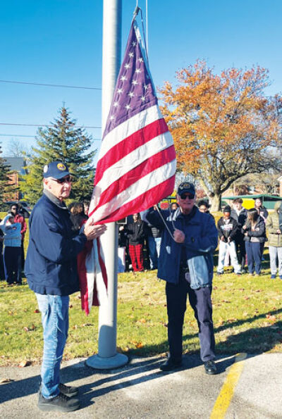  Polish Legion of American Veterans Post No. 169 members Cass Miciuda, left,  and Richard Yandora, right, raise the flag during the Veterans Day celebration  held Nov. 13 at the Warren Consolidated Schools Career Prep Center in  Sterling Heights. Both veterans served in the U.S. Army.  