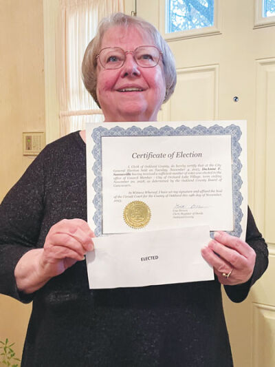  Orchard Lake City Councilwoman DuAnne Sonneville displays her decorative City Council certificate alongside the “elected” ballot that won her the election in a tiebreaker at the county. 