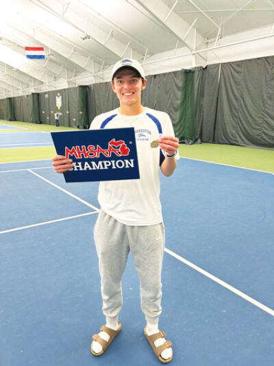 Chad Anderson poses with a MHSAA Champion sign and medal at Midland Tennis Center Oct 18. Anderson had a perfect record in 2025. 