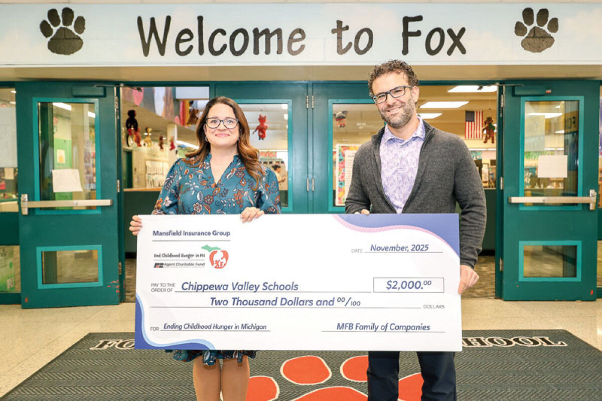  Insurance agency owner Denise Mansfield, left, and Fox Elementary School Principal Frank Bellomo pose with a check for $2,000 that will be used to fund a food pantry at Fox Elementary. 