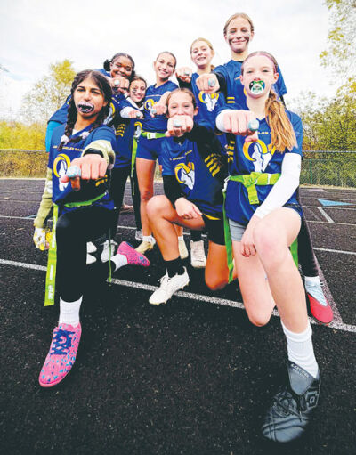  The girls on the flag football team pose with their league championship rings after winning the title. 