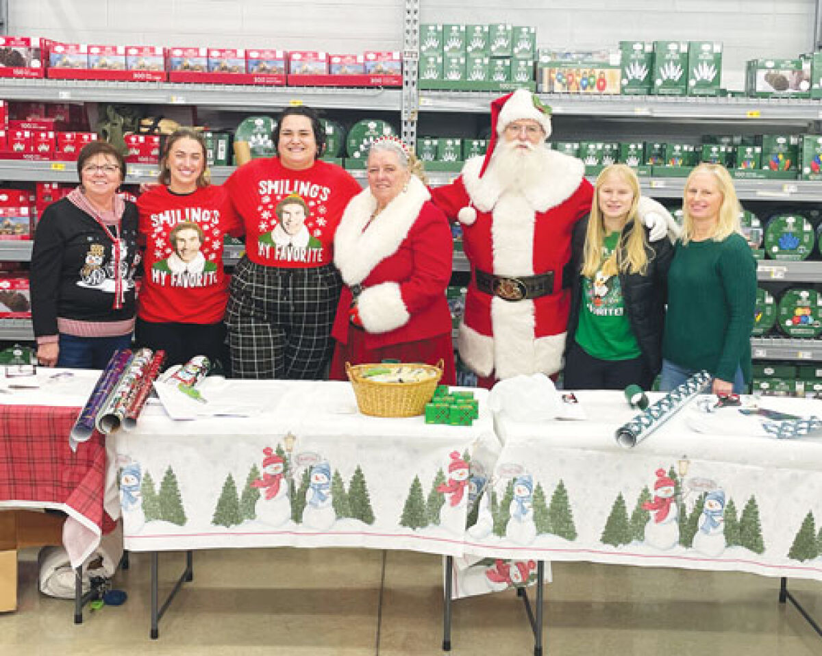  Operation Blue Sleigh organizers pose together  for a photo with Santa.  