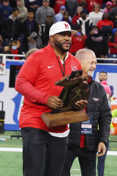  OLSM head football coach Jermaine Gonzales holds the state trophy. 