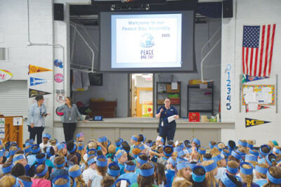  Katie Lewis, in her first year as principal of Rogers Elementary School, leads an assembly for her students. 