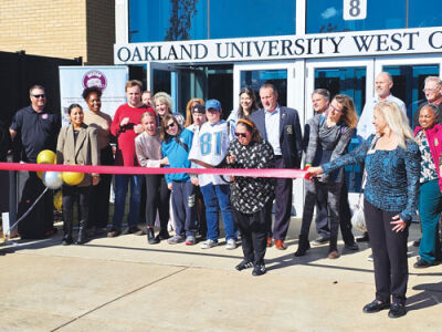  Rebecca Smither, daughter of Dutton Farm founder Michele Smither, cuts the ribbon for Dutton Farm’s new  job readiness program at Oakland University’s west campus.  