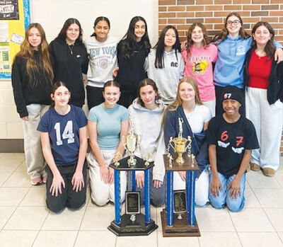  The Reuther girls basketball team poses with trophies earned in back-to-back  seasons. The team won city championships in both years. 