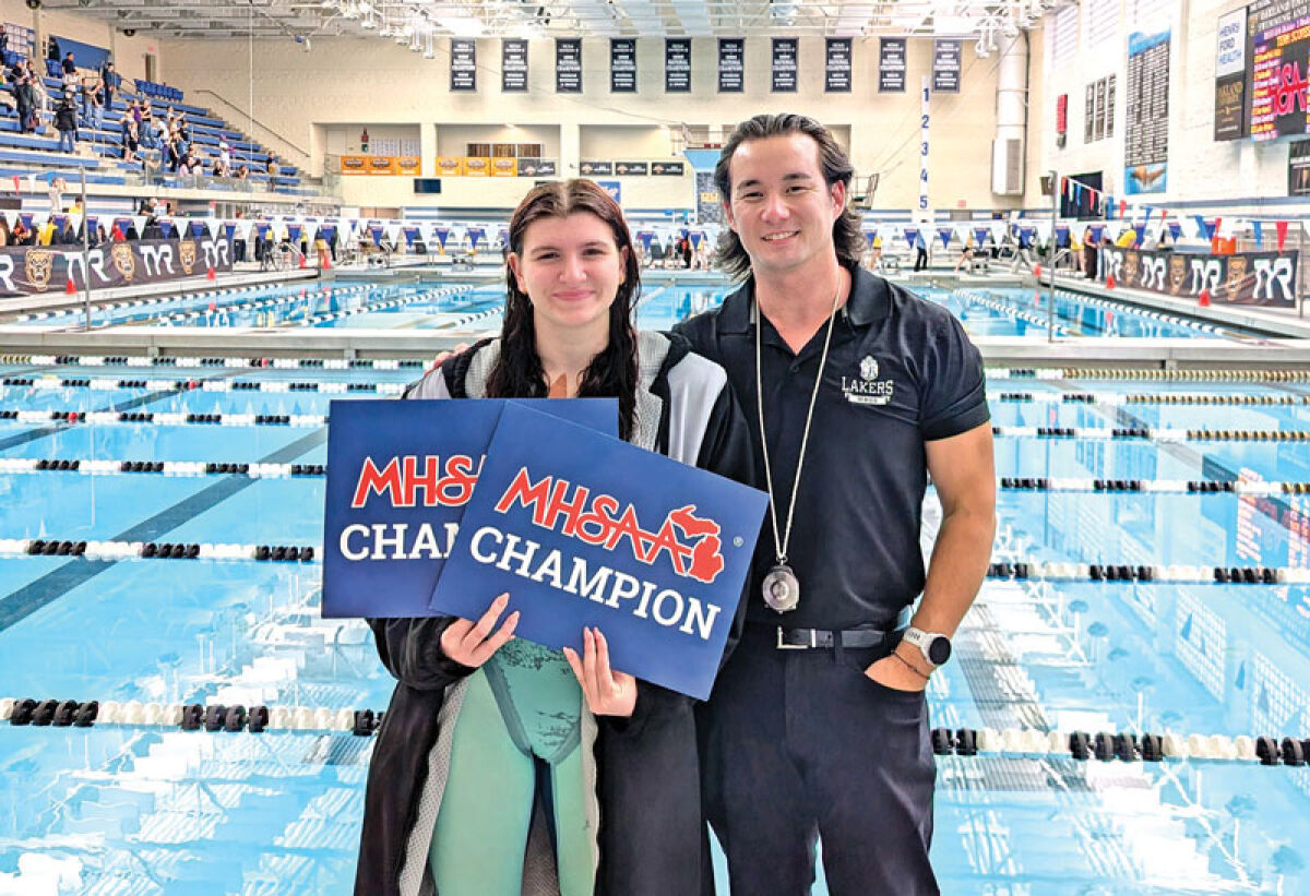 West Bloomfield High senior Elizabeth Eichbrecht poses with head coach Ronson Webster for a picture after Eichbrecht officially ‘four-peated’ the MHSAA Division 1 state meet 200- and 500-yard freestyle events at Oakland University Nov. 21. 