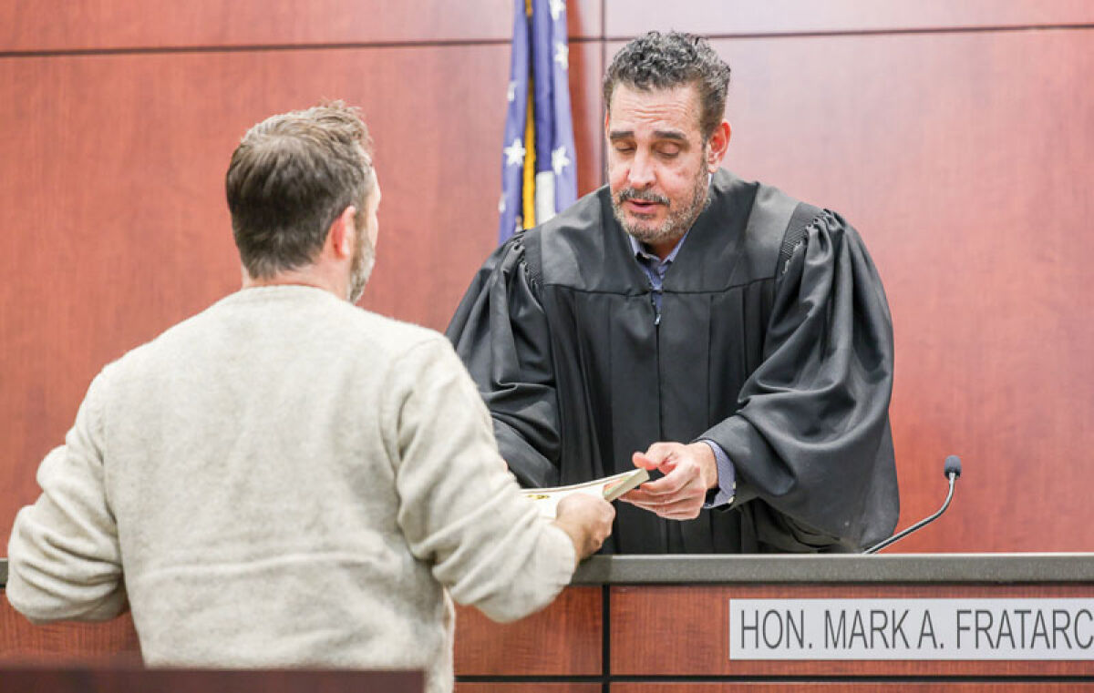  Judge Mark Fratarcangeli gives a drug court participant his certificate for completing phase four of the program on Dec. 3. 