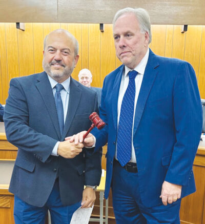  Outgoing Grosse Pointe Farms Mayor Louis Theros passes the gavel to new Mayor John Gillooly at the Nov. 10 Farms City Council meeting. 