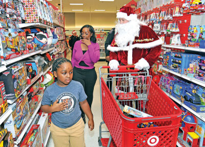  Santa helps Wade Tatum Jr., 8, and Jocelyn Walker shop for gifts. 