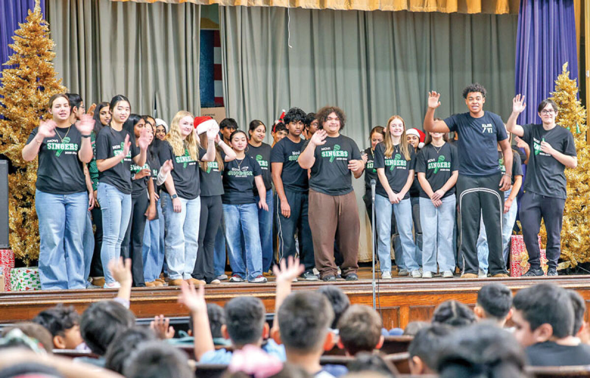  The Novi Singers, the high school’s a capella group, interact with early elementary school children at the Academy of the Americas following their performance on Dec. 11. 