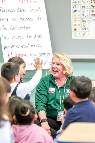  Lori Osborne, a sixth grade teacher at Novi Meadows, interacts with first grade children. 
