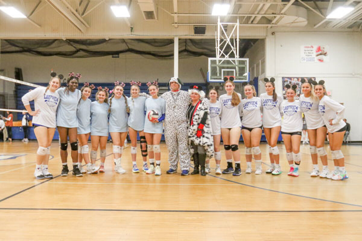  Lakeview coach Tom Pfeifer and his wife, dressed in their Disney-themed costume, take a photo with the team. 