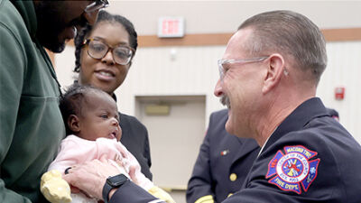  Parents Stephan Smith and Leeshauna Brown joined Macomb Township Fire Department Capt. Ken Bartz, who holds 1-month-old Amarla Brown for the first time after helping deliver her at home. 
