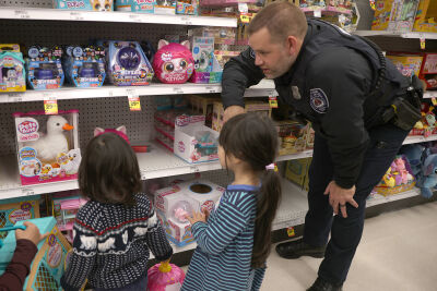  Royal Oak police officer Kevin Cavanaugh helps Aurora Sousa, 4, and Phoenix Sousa, 2, of Royal Oak, shop for Pets Alive toy animals. 