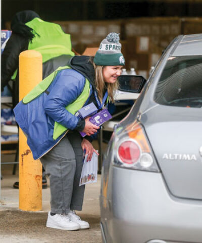  Katie Paratore, a public health emergency preparedness specialist with the Macomb County Health Department, delivers filters to an Eastpointe resident at a drive-thru distribution station. 