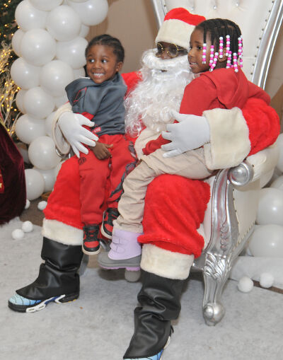 Siblings Donelle, 3, left, and Cherish Singley, 4, right, meet Santa at the toy drive.